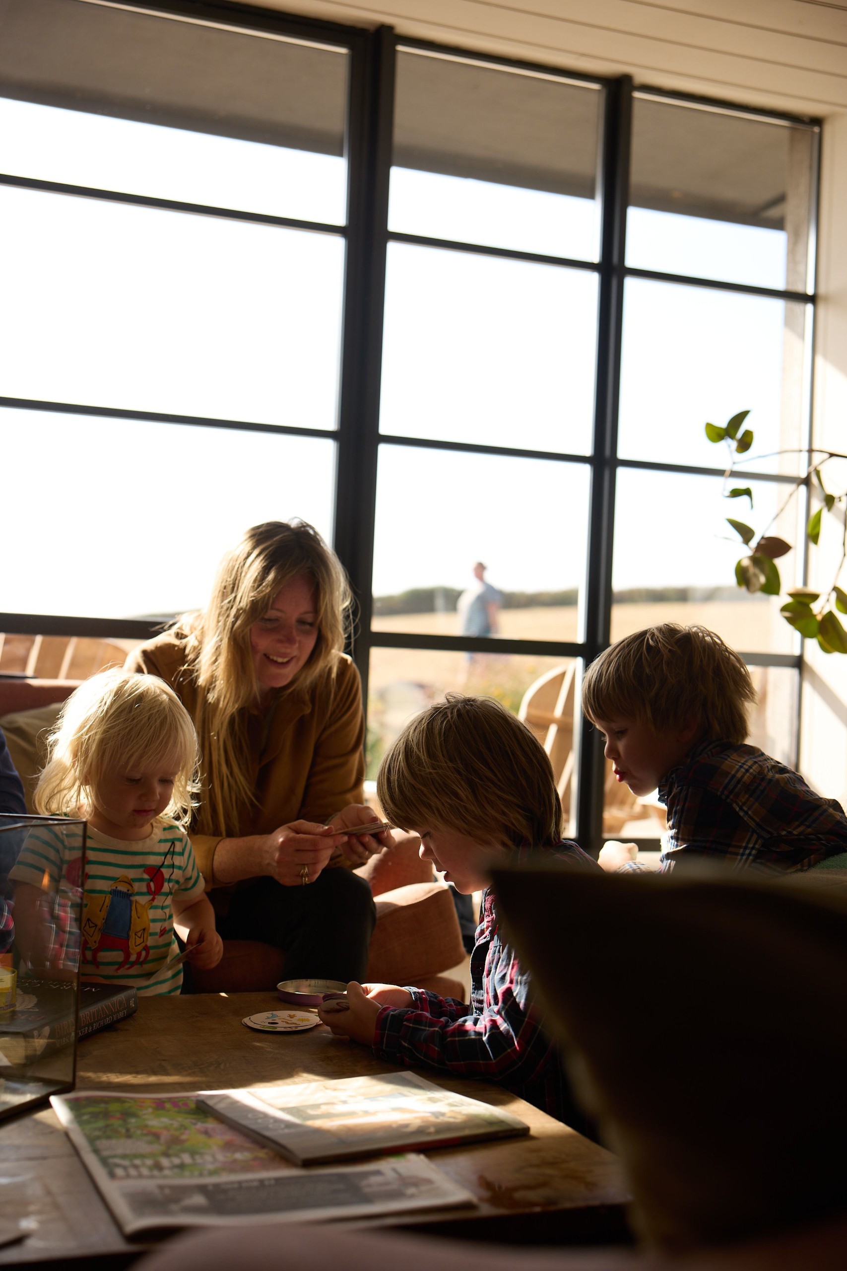Family playing a card game at a table by the window